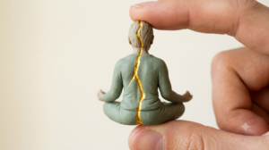 A sculpted matte clay seated human figure breathing calmly, with a bright continuous golden line tracing the length of the form.