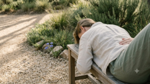 A person lies on their back with one hand resting on their chest, breathing slowly in a calm, softly lit room.