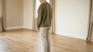 A person humming with one hand resting flat on their chest in soft natural light.